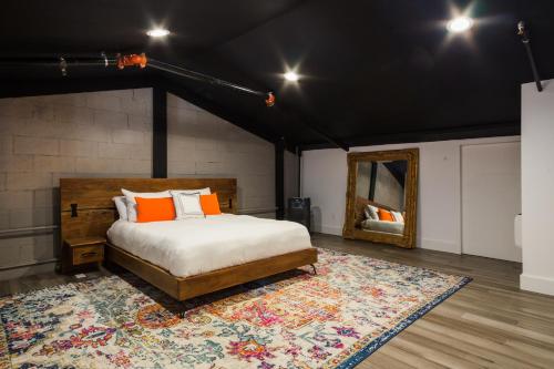 佩塔卢马Petaluma Warehouse Lofts unit E的一间卧室配有一张床、地毯和镜子