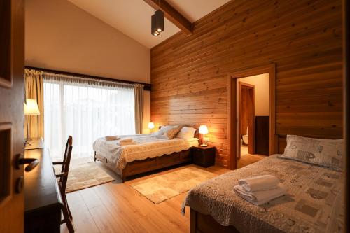 班斯科Villa Katerina Deluxe - Pirin Golf and Country Club的一间卧室设有两张床和窗户。
