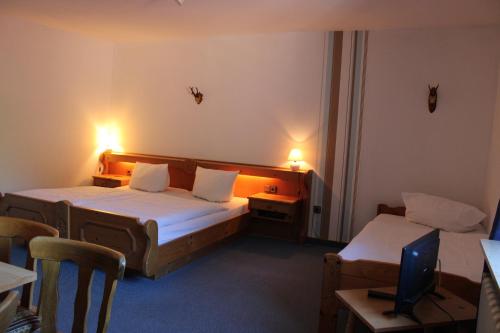 肖顿Berggasthof Hoherodskopf的酒店客房带两张床和一张桌子以及椅子。