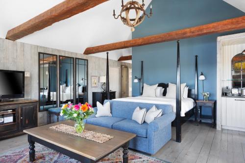 北哈特利Manoir Hovey, Relais & Châteaux的客厅配有蓝色的沙发和床。