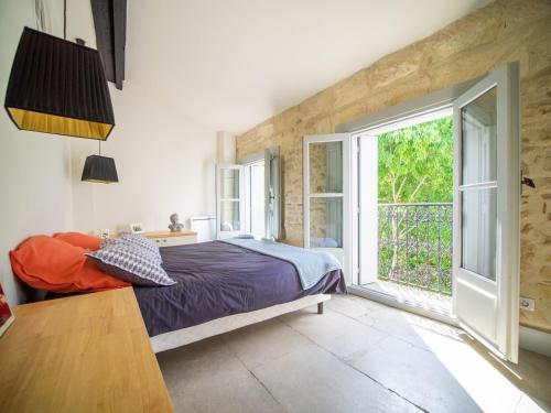 蒙彼利埃Le Platane de la canourgue的一间卧室设有一张床和一个大窗户