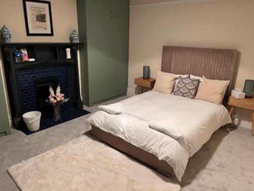 伦敦Luxury Cosy Retreat Apt的一间卧室配有一张床和一个壁炉
