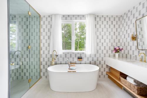 北哈特利Manoir Hovey, Relais & Châteaux的白色的浴室设有浴缸和窗户。
