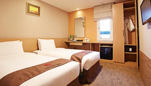 首尔空中花园酒店明洞3号店的酒店客房设有两张床和电视。