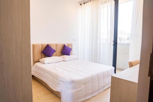 拉维尼亚山Zayn villa的卧室配有白色床和紫色枕头
