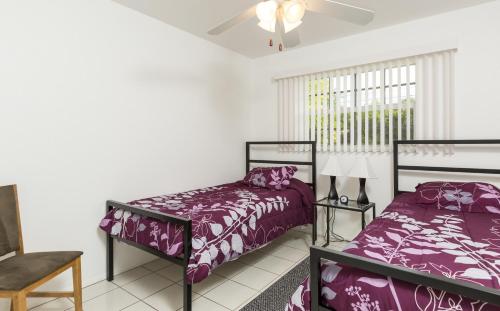 夏洛特港范奈斯度假屋的一间卧室设有两张床和窗户。