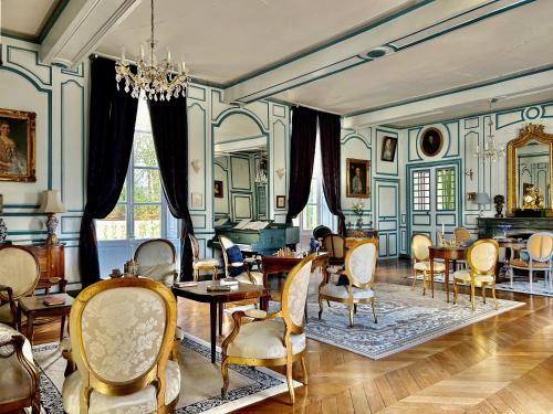 贝莱姆Château des Feugerets的客厅配有桌椅和吊灯。