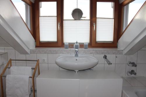 基姆湖畔贝尔瑙Ferienwohnung Bernau的一间带水槽和镜子的浴室以及窗户。