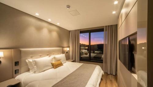 格拉玛多CHATEAU DU GOLDEN的卧室设有一张白色大床和一扇窗户。