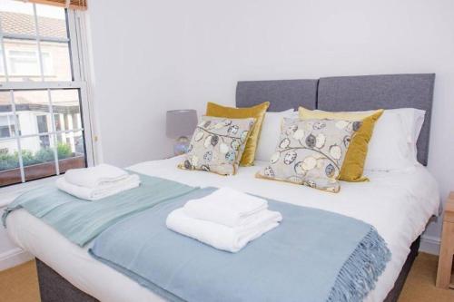 ChestertonMidsummer Cottage Cambridge的床上配有毛巾和枕头,设有窗户