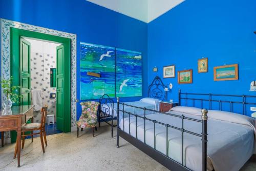 库特罗菲安诺Villa Sirgole 1897的蓝色卧室配有一张床和一张书桌