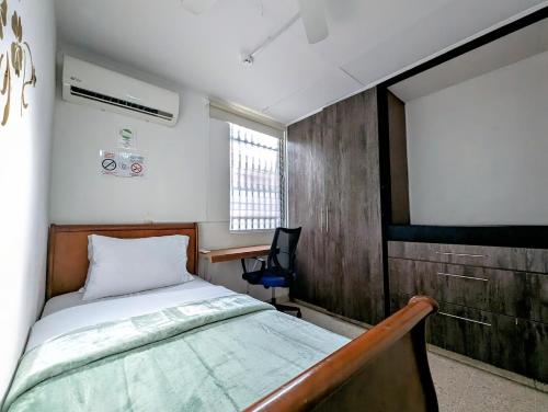 巴拿马城Hostal Yoha的一间卧室配有一张床、一张书桌和一个窗户。