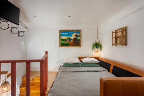 里斯本Casa Aurora - bairro típico a minutos do Terreiro的客厅配有床和沙发