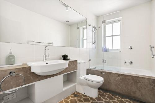 悉尼Balmain Wharf l 2 Bedroom Apartment的一间带水槽、卫生间和镜子的浴室