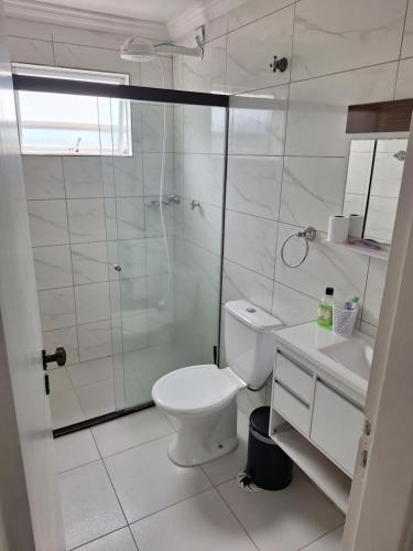 瓜鲁雅Cobertura Guarujá的一间带卫生间和玻璃淋浴间的浴室