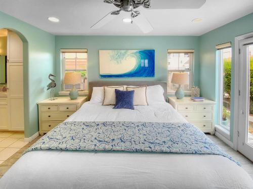 圣地亚哥Massive Mission Beach Home - Fire Pit & Deck的一间卧室配有一张蓝色墙壁和窗户的床
