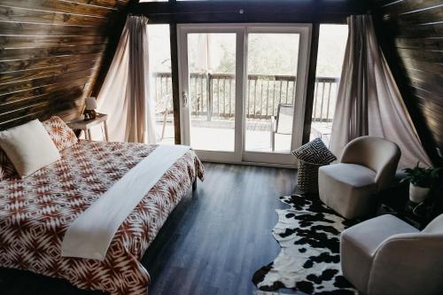新布朗费尔斯The Maverick: A-Frame w/ Hammock and Tree Top View的卧室配有床、椅子和窗户。