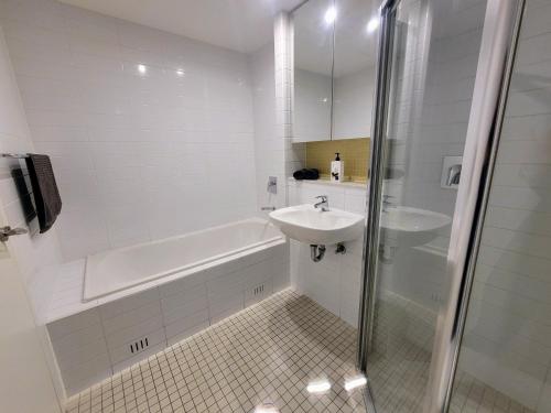 格莱内尔格CityViews @ Glenelg * Pool/Beach * Free Parking *的白色的浴室设有水槽和浴缸。