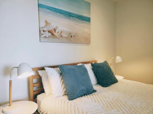 格莱内尔格CityViews @ Glenelg * Pool/Beach * Free Parking *的一间卧室配有一张带蓝色和白色枕头的床