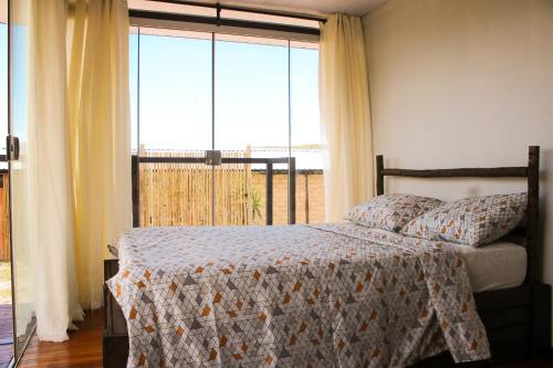 戈亚斯州上帕莱索Dolaço na Chapada- Hospedagem的一间卧室设有一张床和一个大窗户