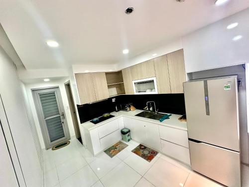 胡志明市Scenic Valley Suite的厨房配有白色橱柜和不锈钢冰箱