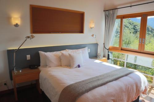 Arthur's Bay千洞湾度假酒店的一间卧室设有一张大床和一个窗户。
