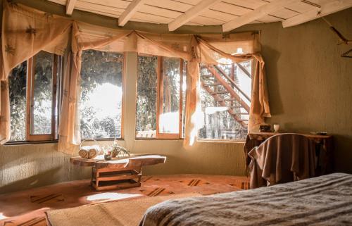 圣佩德罗拉拉古纳Bambuddha - Garden Suite at Lakehouse的卧室配有床、桌子和窗户。