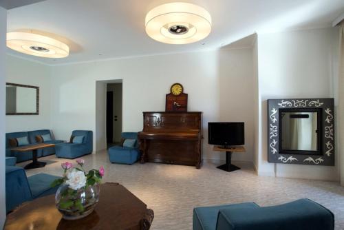 萨包迪亚Hotel Il Gabbiano的客厅配有钢琴和蓝色家具