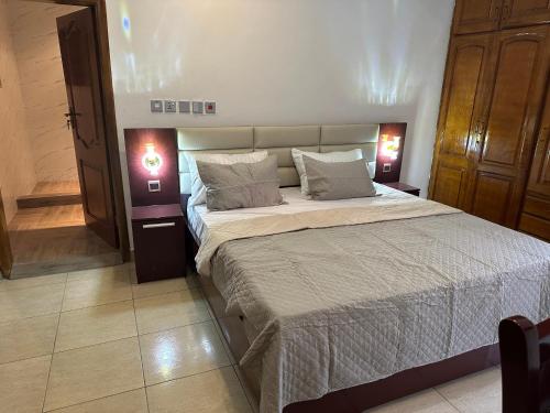 库马西D Barfi Guesthouse, excellent location的一间卧室配有一张大床和两盏灯