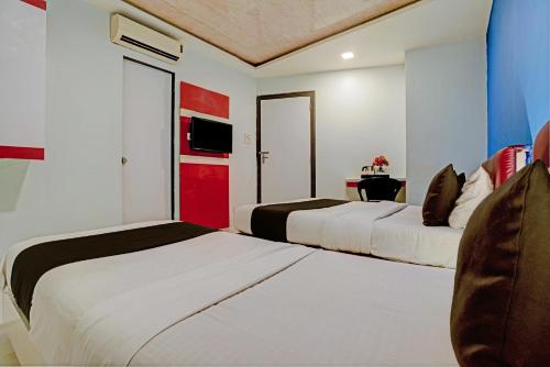 孟买OYO Hotel Blue Sea Near Chhatrapati Shivaji International Airport的红色和白色的酒店客房内的两张床