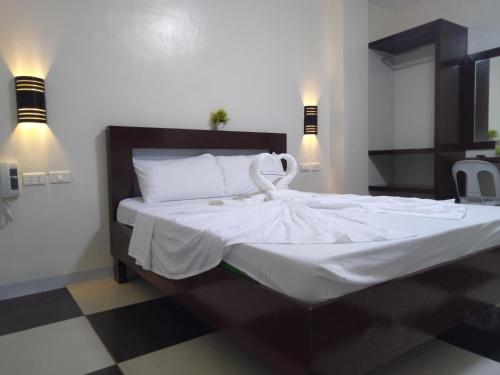 波尔多·格尼拉Bayside Exceel Hotel的一间卧室配有一张带白色床单的大床