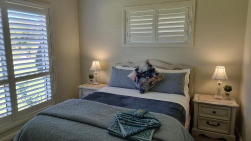 WinghamLittle Britton的一间卧室配有一张带蓝色床单的床和一扇窗户。