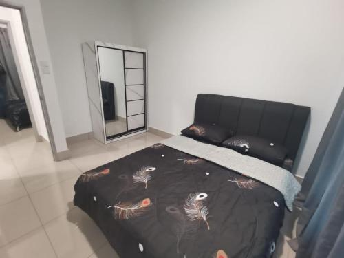 吉隆坡RC Firdaus Homestay Kuala Lumpur的一间卧室配有一张带黑色毯子和镜子的床