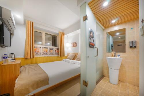哈尔滨哈尔滨哈什国际青年旅舍哈尔滨西站店的一间带床的小卧室和一间浴室