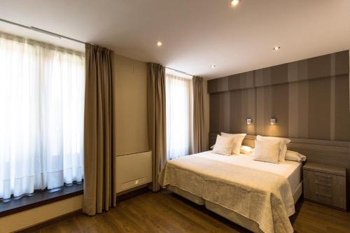 利亚内斯利亚内斯旅游公寓酒店的一间卧室设有一张床和一个大窗户