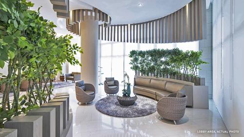 马尼拉Grace Residences Elevate Escapes的大堂配有沙发、椅子和植物