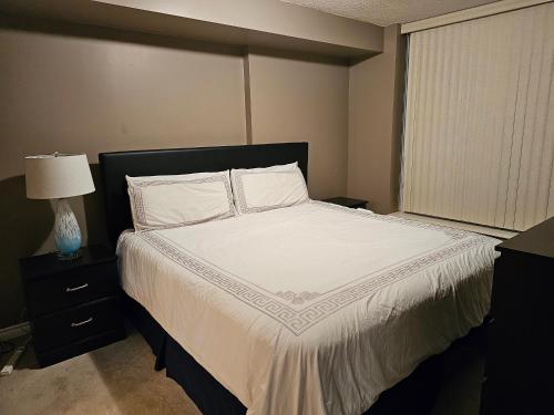 多伦多Private Ensuite Room in Luxury Condo的一间卧室配有一张带白色床单的床和一扇窗户。