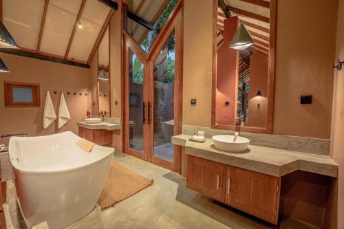希克杜沃Nisala Villas的带浴缸、水槽和镜子的浴室
