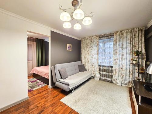 阿拉木图Nadezhda Apartments on Nayryzbay batyr 82的带沙发和床的客厅以及窗户。