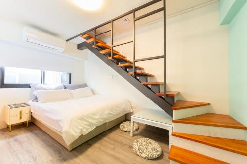 台南南驿风尚民宿(NAN YI STYLE) 的一间卧室设有一张床和一个楼梯