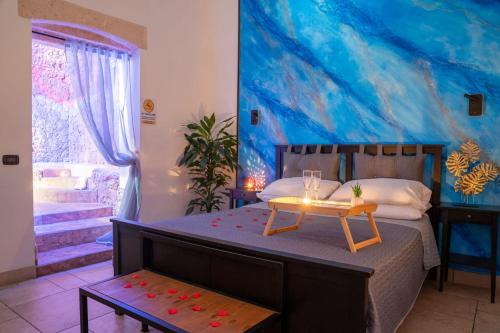 布林迪西B&B La Sorgente的一间卧室配有一张带桌子和绘画的床
