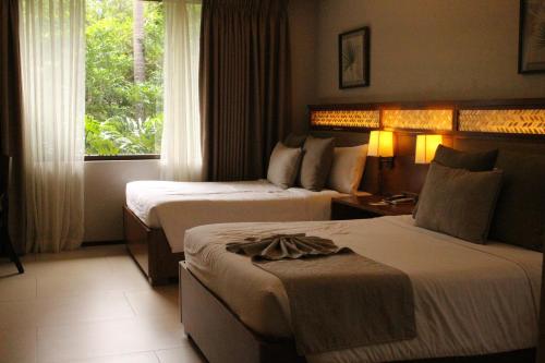 圣胡安El Jardin de Zaida Managed by HII的酒店客房设有两张床和窗户。