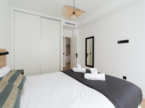 大加那利岛拉斯帕尔马斯Pascal Home By CanariasGetaway的卧室配有一张带2条毛巾的大型白色床
