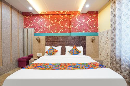 KakarmathaFabHotel RS Residency的卧室配有一张带彩色枕头的大型白色床。