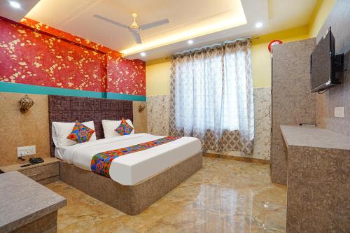 KakarmathaFabHotel RS Residency的一间卧室配有一张大床和电视