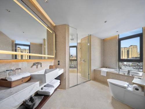 菏泽菏泽希尔顿花园酒店				的浴室配有2个盥洗盆、浴缸和淋浴。