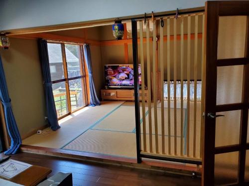 高松Oyado Nagomi - Vacation STAY 29876v的一间带电视和滑动玻璃门的客厅