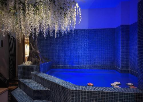 勒芒Leprince Hotel Spa; Best Western Premier Collection的蓝色瓷砖的房间的蓝色浴缸