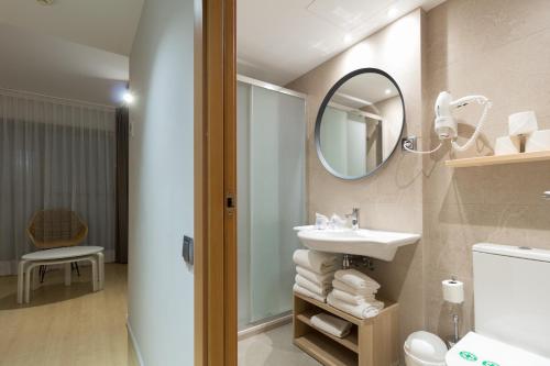 卡斯特尔德费尔斯皇家滨海花园公寓的一间带水槽和镜子的浴室