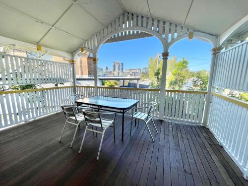 布里斯班Minto Accommodation Brisbane的阳台的门廊配有桌椅